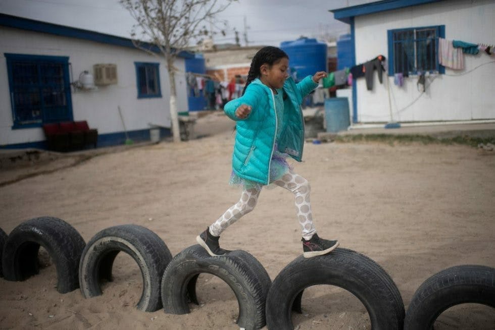 Young girl walking on tires